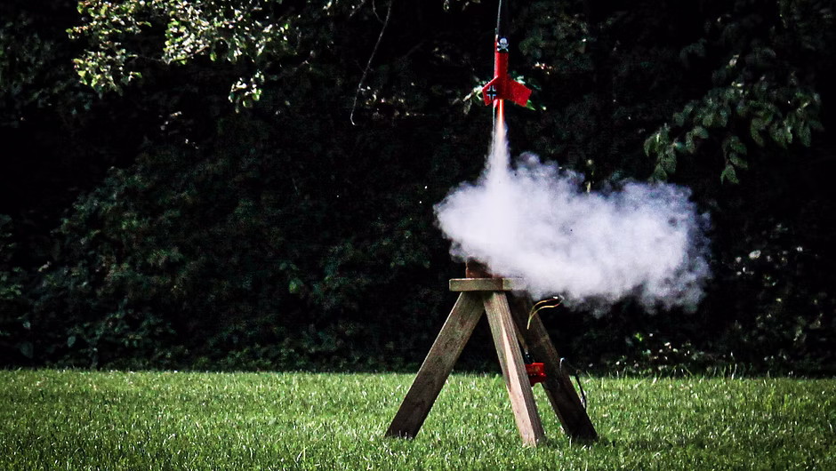 A red model rocket displayed at a club event