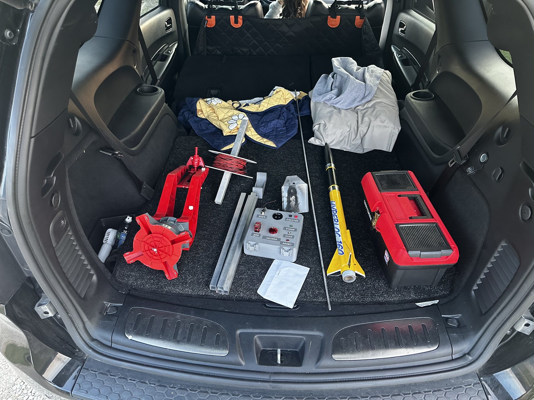 Rocketry equipment, launch controls, and a yellow rocket packed for the range