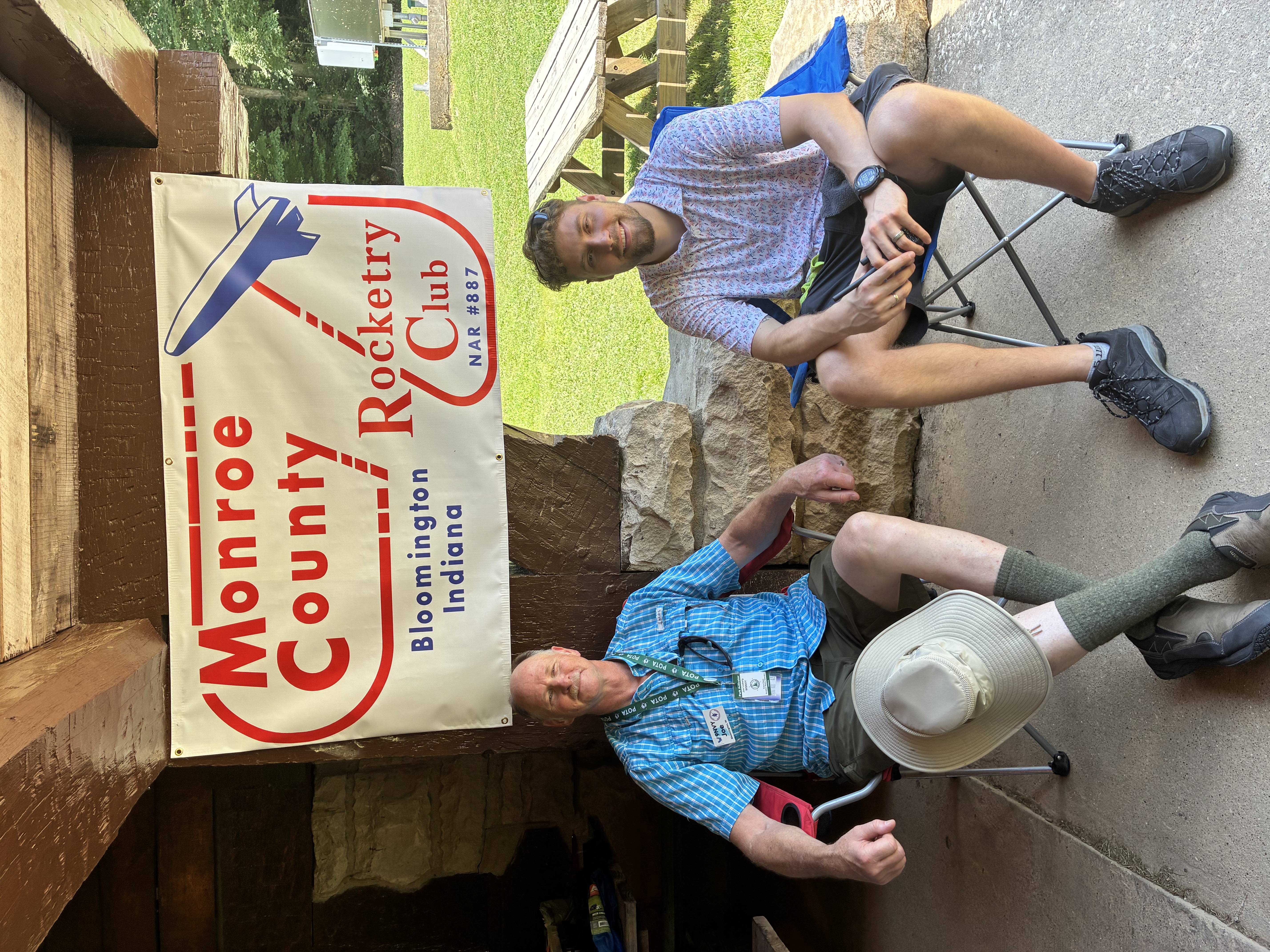 Joe and Braydon seated beneath the Monroe County Rocketry Club banner
